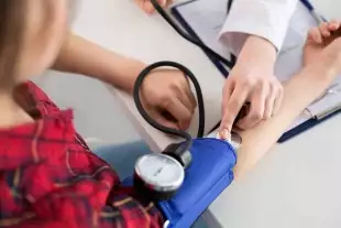 Médecin femme qui mesure la tension artérielle